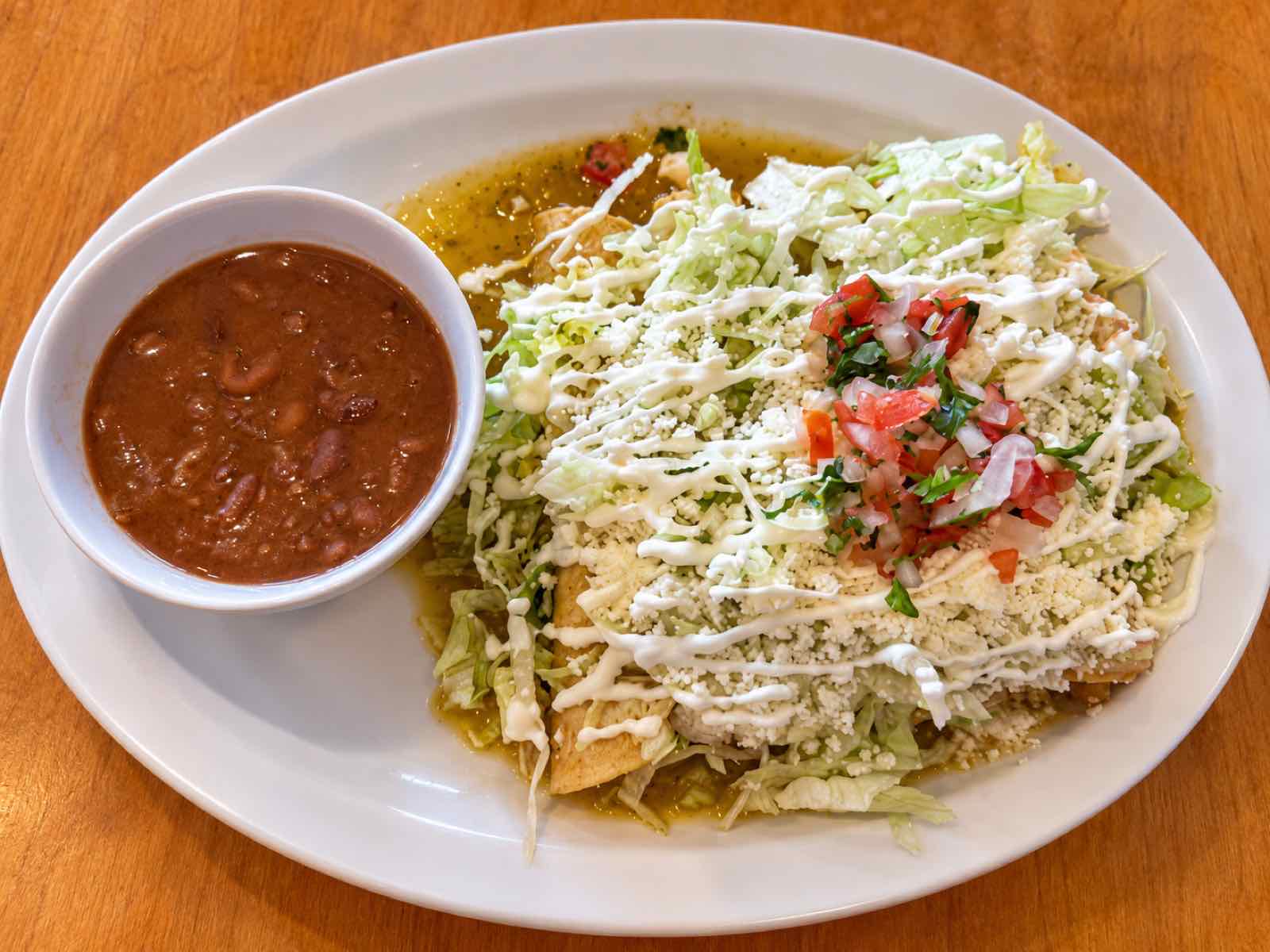 Enchiladas verdes with lettuce, crema, queso fresco and pico de gallo